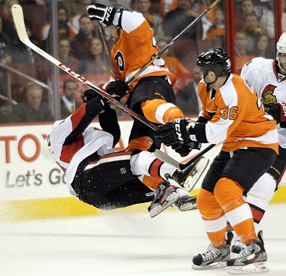 Philly's Harry Zolnierczyk goes high to lay out Mike Lundin, drawing a five-minute major and ejection.  (AP)