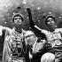 In this March 24, 1969, file photo, UCLA coach John Wooden is flanked by Sidney Wicks, right, and Lew Alcindor, draped with basket ropes, after the UCLA team beat Purdue 92-72 to win the NCAA basketball title for the third consecutive year, in Louisville, Ky. (AP Photo, File)