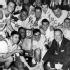 in this March 22, 1964, file photo UCLA coach John Wooden, right, and members of the Bruin team smile over victory that brought them the NCAA basketball championship trophy, March 22, 1964, Kansas City, Mo. UCLA downed the Duke University team, 98 to 83, in the final game to complete their season with 30 straight wins. Players in front row are, from left: Gail Goodrich, Walt Hazzard and Jack Hirsch, holding trophy. Man directly behind Hirsch and Coach Wooden is Keith Erickson. Wooden, college basketball's gentlemanly Wizard of Westwood who built one of the greatest dynasties in all of sports at UCLA and became one of the most revered coaches ever, has died. He was 99. (AP Photo, File)
