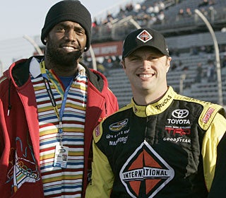 Randy Moss poses with team driver Travis Kvapil before the trucks race at Darlington on March 12. (AP)