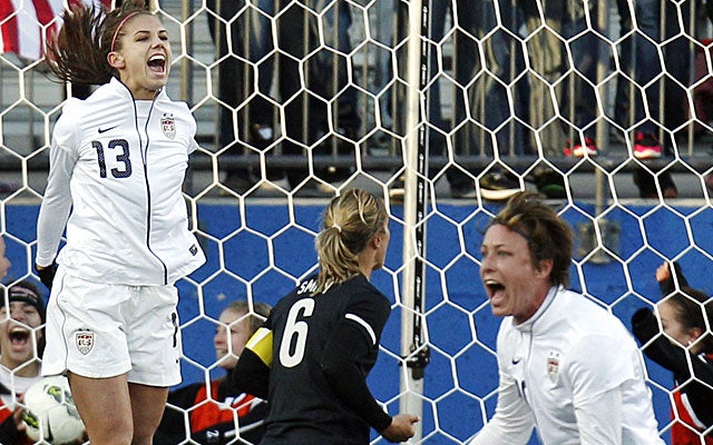 Alex Morgan (13) and Abby Wambach (right) celebrate Morgan's winning goal. (AP)