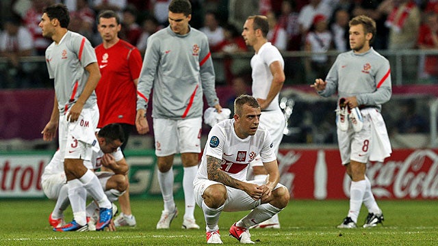 Polish players are dejected after the co-host nation is eliminated in the group stage. (AP)