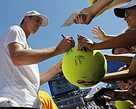 American Sam Querrey signs some autographs after his mild upset victory. (AP)
