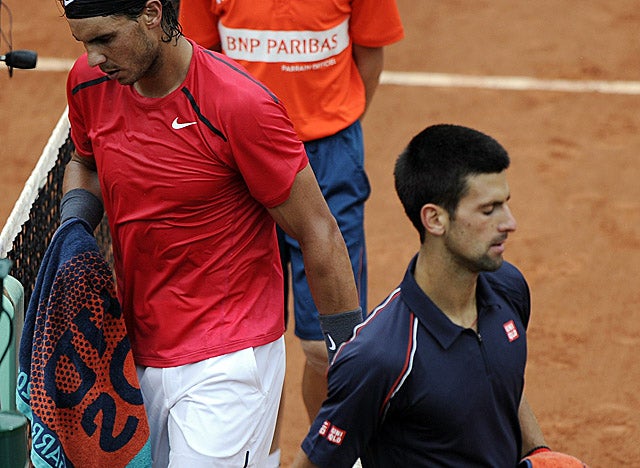 Nadal and Djokovic head for their respective chairs as a second rain delay is called Sunday. (Getty Images)