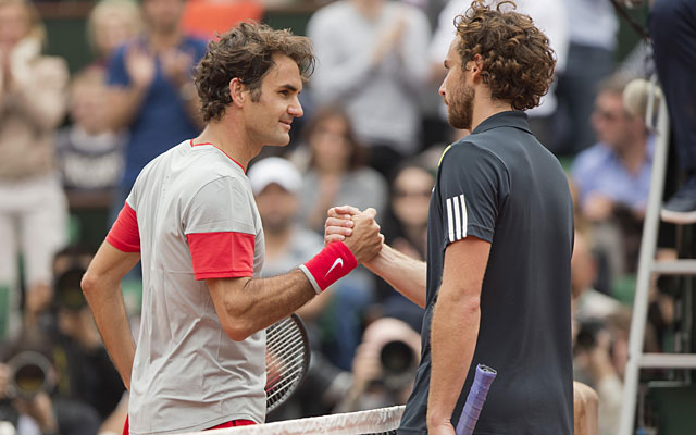 Roger Federer (left) meets Ernest Gulbis at the net to shake hands after their fourth-round match. (USATSI)