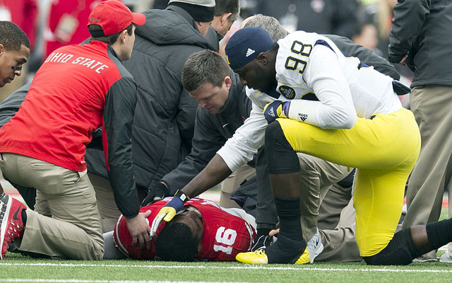 J.T. Barrett lays on the ground while Michigan's Devin Gardner checks on him.