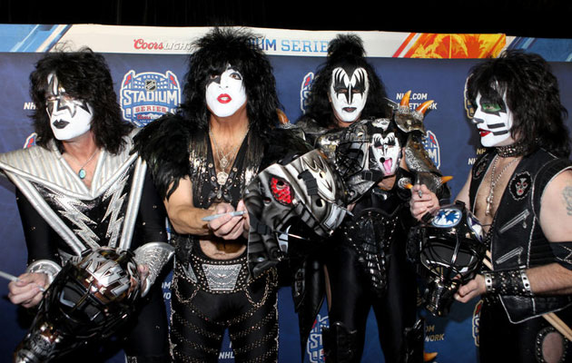 KISS autographs and poses with their custom goalie masks. (NHL)