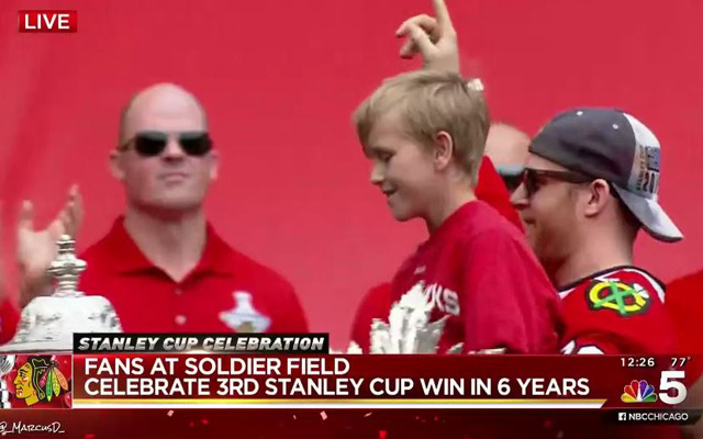 Kris Versteeg holds up the son of late equipment manager Clint Reif. (NBC 5/@_MarcusD_)