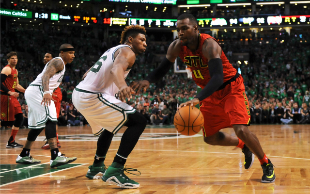 Marcus Smart stays in front of Paul Millsap.  (USATSI)