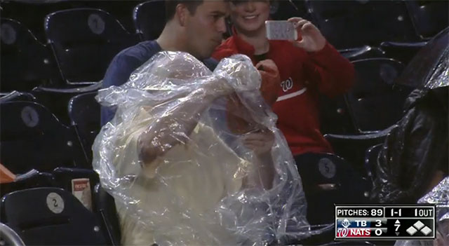 Nats fan struggles to put on rain poncho 