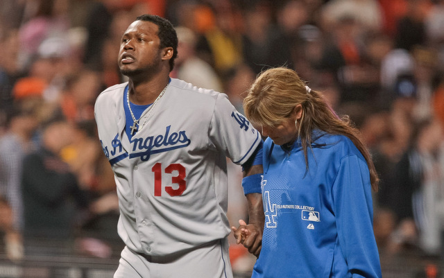 Los Angeles Dodgers' Dee Gordon holds on to his helmet as he