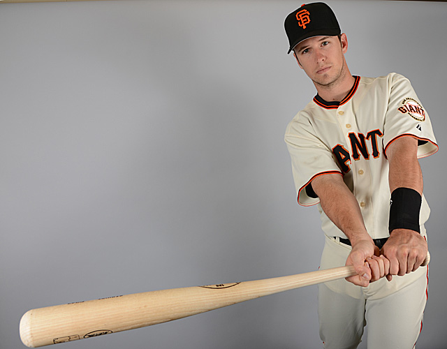 Former San Francisco Giant Buster Posey, without cap, watches the