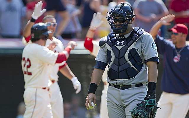 Mariners catcher Jesus Montero is disappointed while the Indians celebrate their victory.
