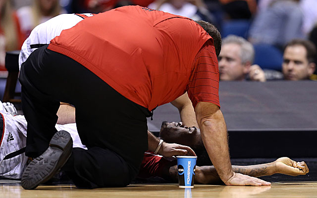 Trainers tend to Louisville's Kevin Ware after the sophomore guard breaks his leg against Duke. (Getty Images)