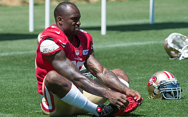 Vernon Davis reported to Niners camp, but he still wants a new contract.  (USATSI)